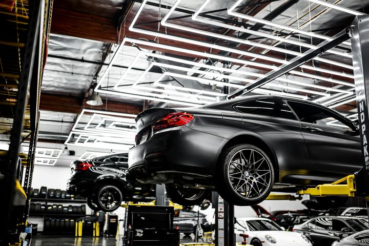 Photo of several cars on lifts in a service center