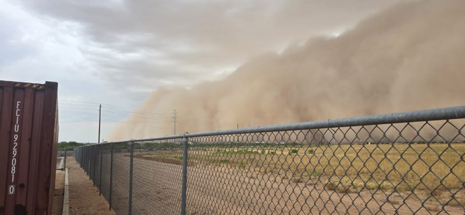 Large monsoon dust and rain wall moving across a field in Pinal County, Arizona, as severe weather brought flash flooding and hazardous driving conditions during school transportation operations.