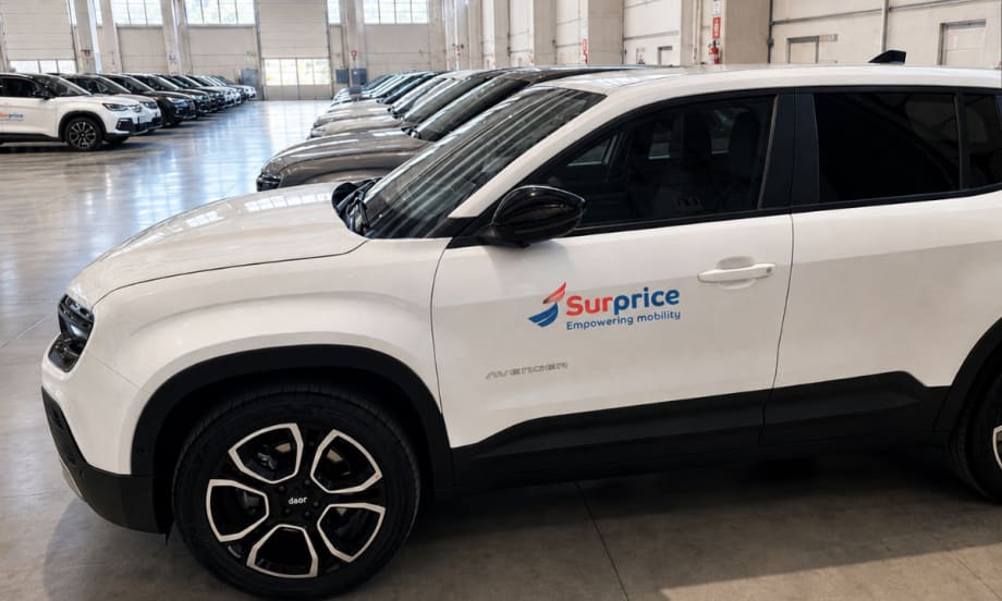 Close up of a row of white CUVs in the Surprice Mobility fleet at the Milan airport.