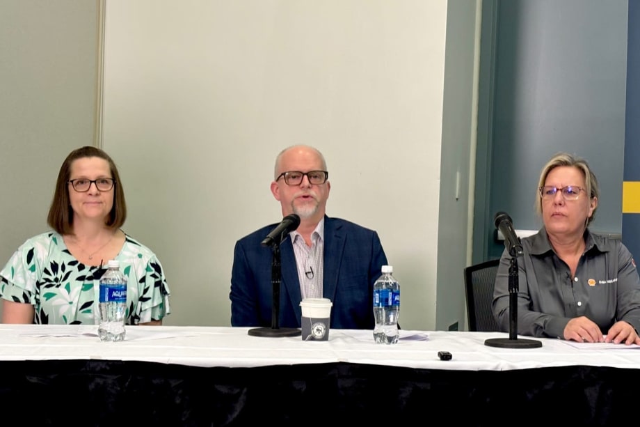 Three people at a table for a panel discussion