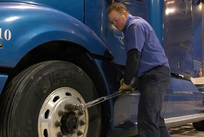 Truck mechanic tightening wheel nuts