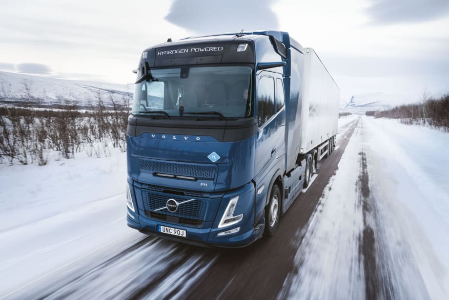 Blue Volvo European cabover truck on snowy road