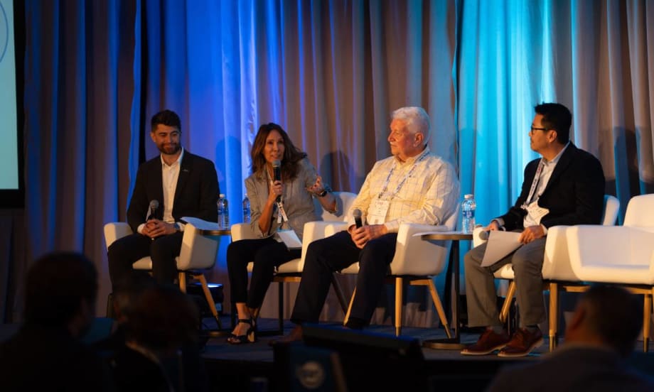 A panel of remarketing managers and experts on stage before a conference audience.