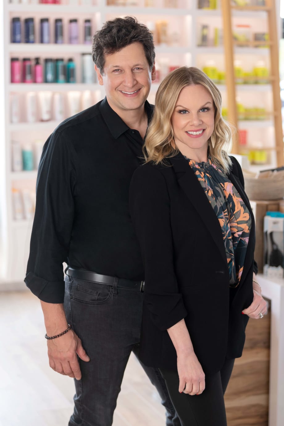 A couple proudly stand in their renovated salon.