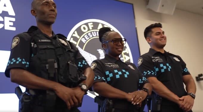 Three Atlanta police officers standing together at official press conference