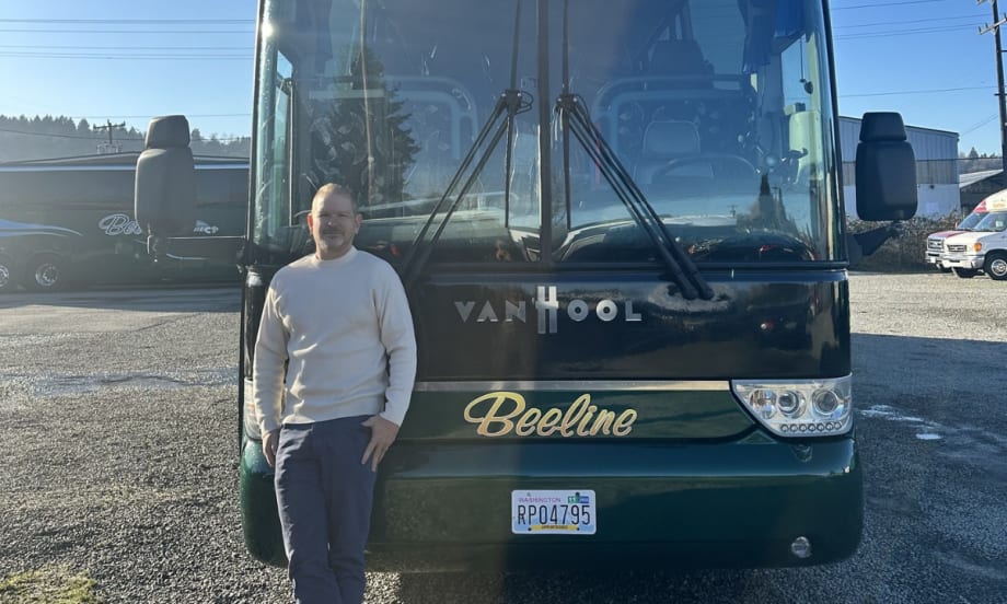Buslane Founder and CEO Michael Rogers poses in front of a charter bus.