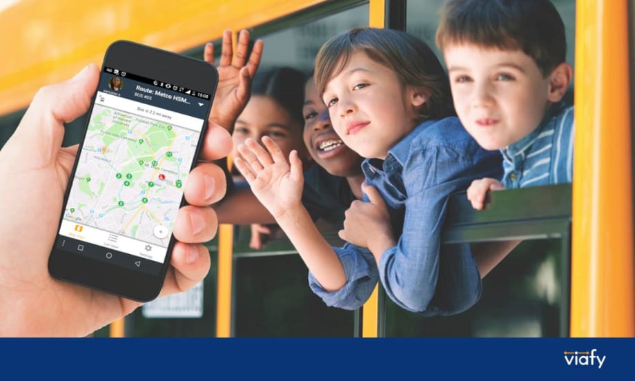 Students waving outside a bus window with an overlay of a hand holding a phone with a transportation tracking app open.