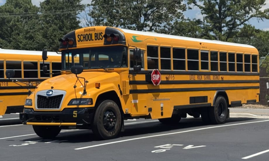 A yellow Little Rock School District school bus in a parking spot.