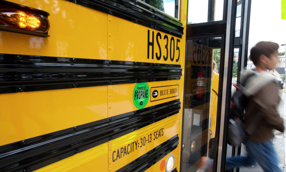 A student disembarks a propane school bus.