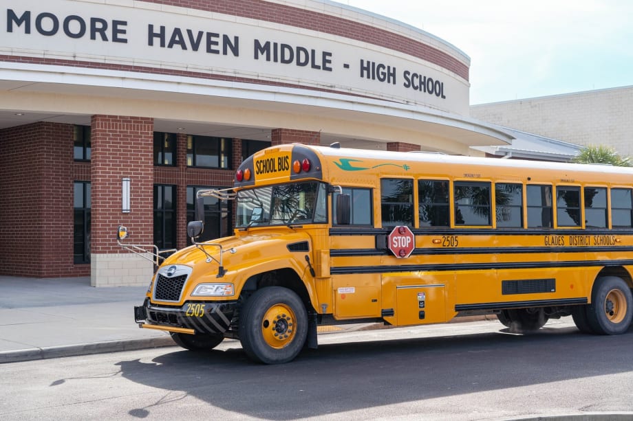 an electric school bus in front of a school