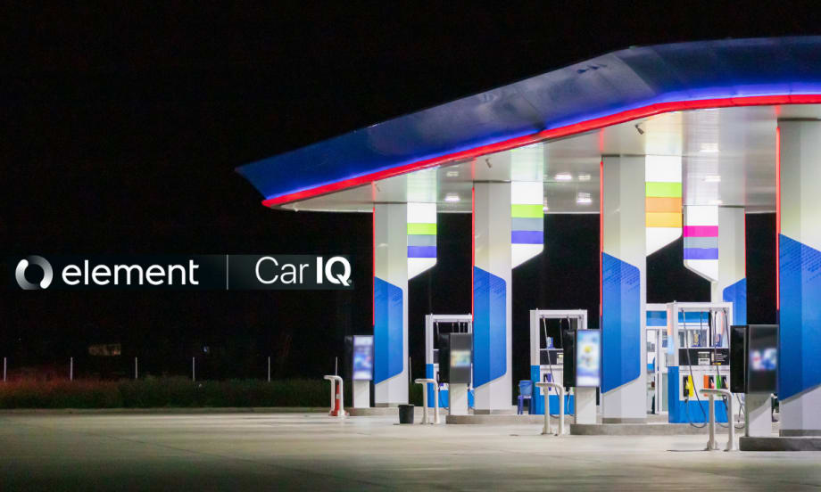 A gas station late at night sits on the right side of a dark photo.