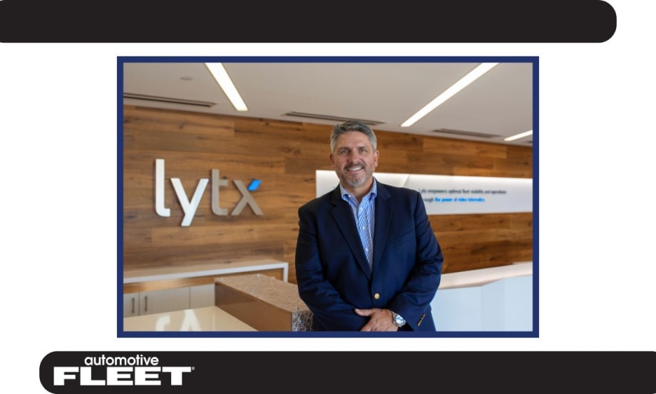 Chris Cabrera, newly appointed CEO of Lytx, stands in the company’s lobby, smiling in front of the Lytx logo.