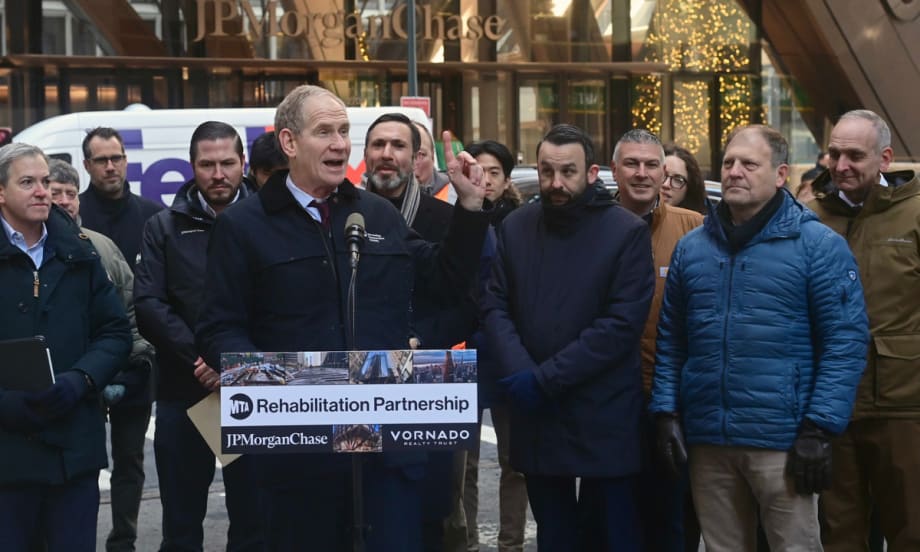 MTA Chair and CEO Janno Lieber stands at a podium in front of a crowd outside the JPMorganChase building.