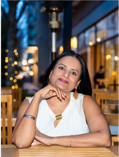 A woman sitting at a table and smiling.