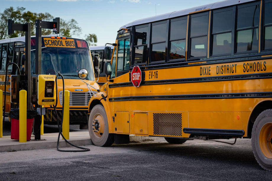 two school buses park in ev charging spots