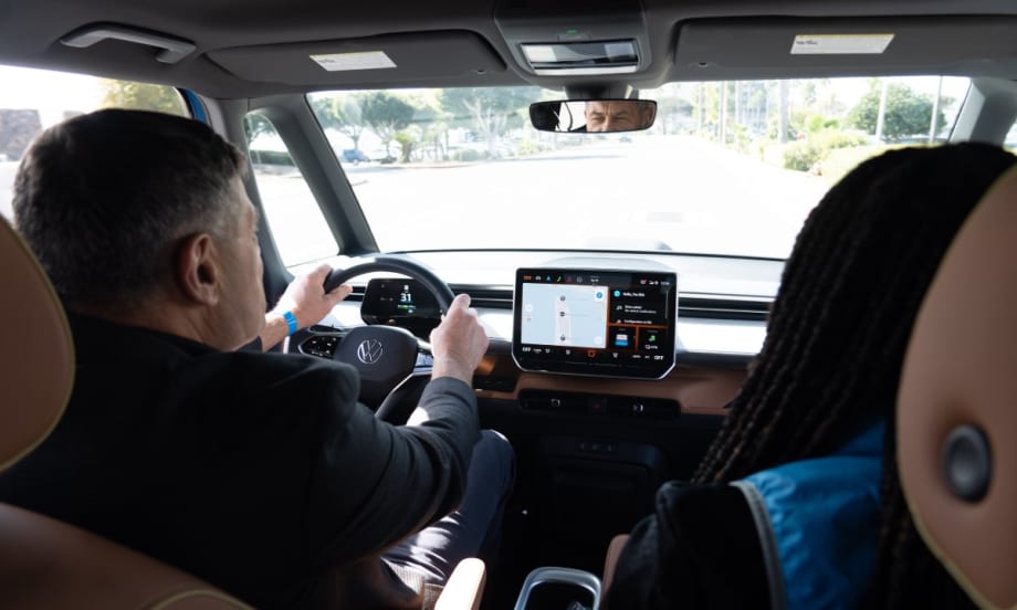 Interior shot of two people test driving a Volkswagen car.