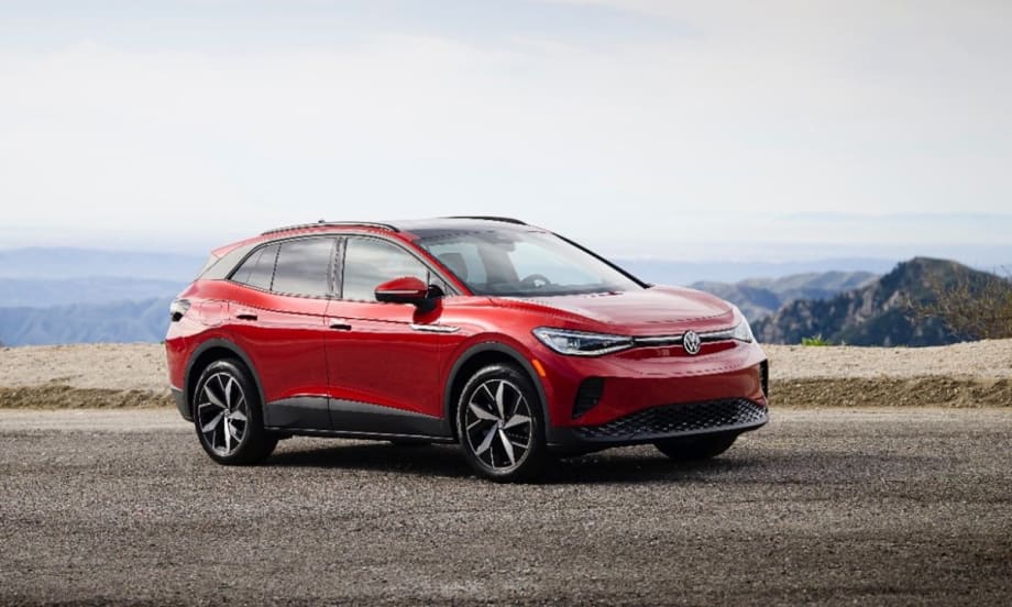 A red 2025 Volkswagen ID.4 parked on a road overlooking mountains.
