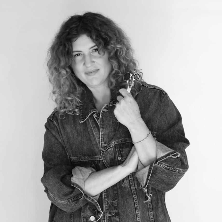 a woman with curly hair holding scissors