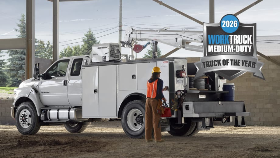 Ford F-650 or F-750 medium-duty work truck with service body and aerial lift at a jobsite with 2026 Work Truck Medium-Duty Truck of the Year badge.