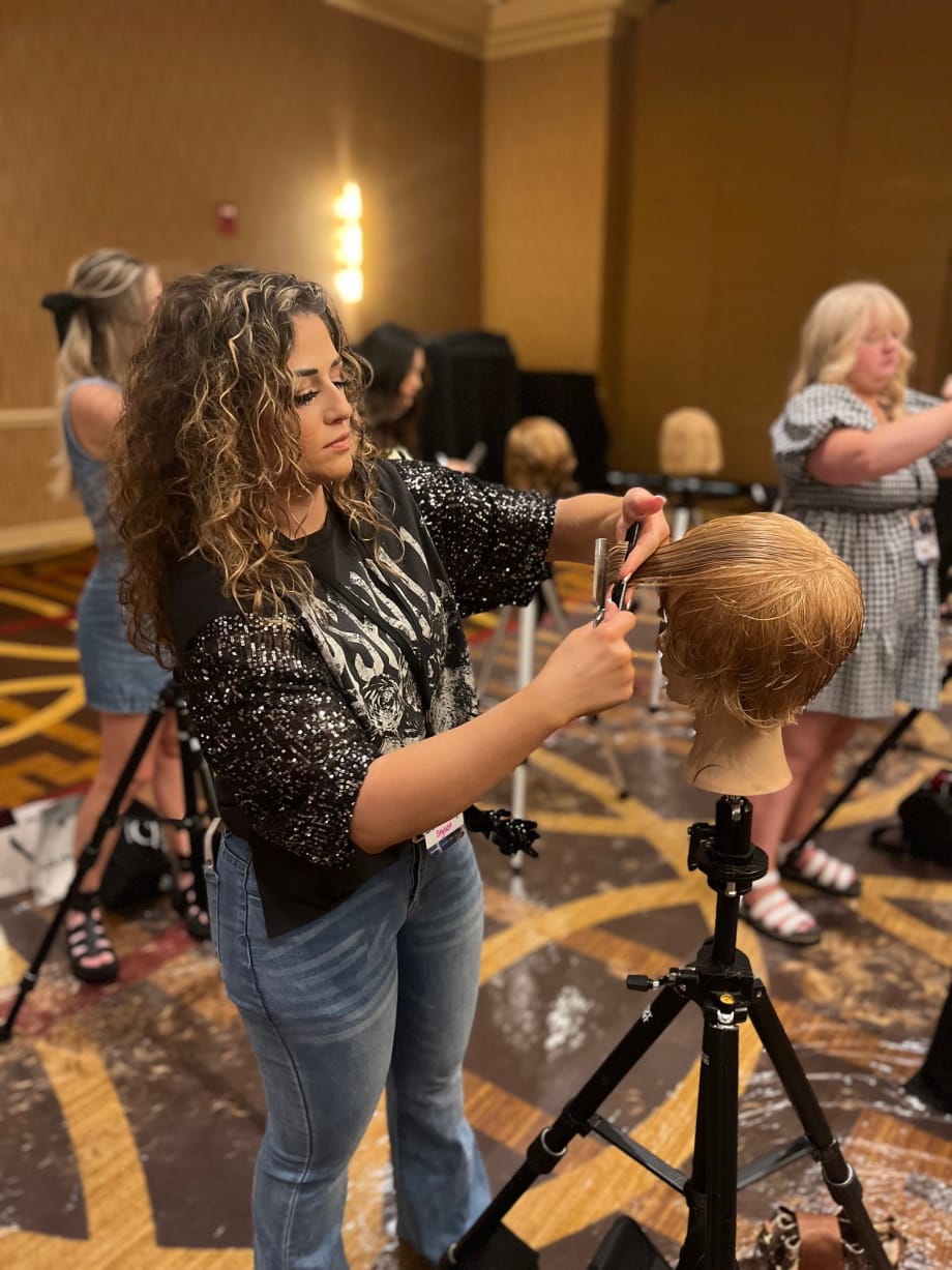 A hairstylist working on a mannequin