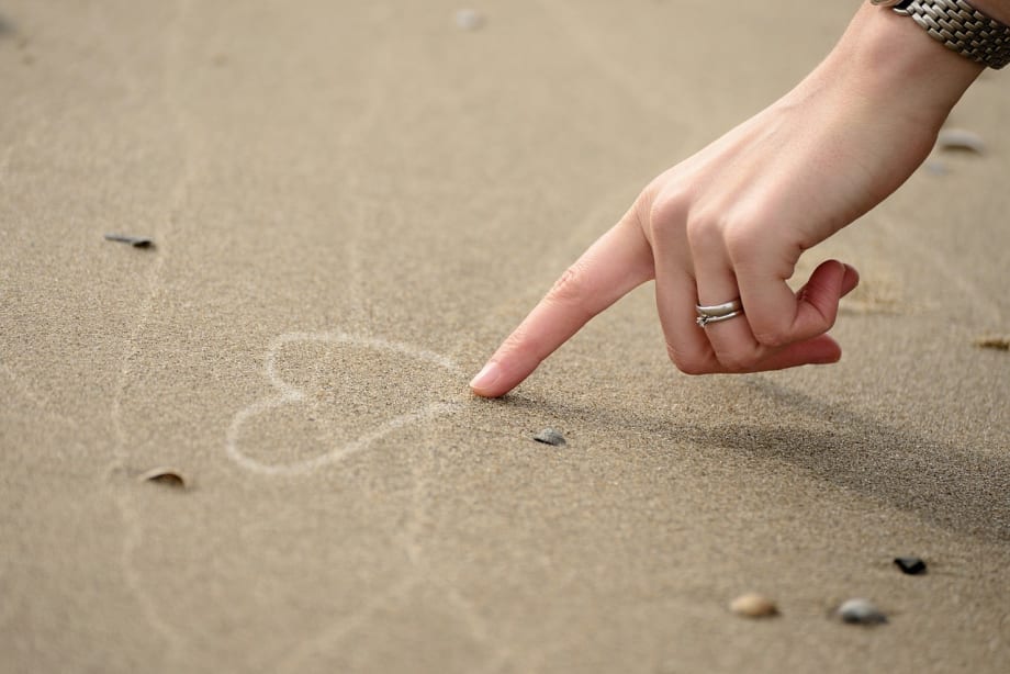 Drawing a heart in the sand.