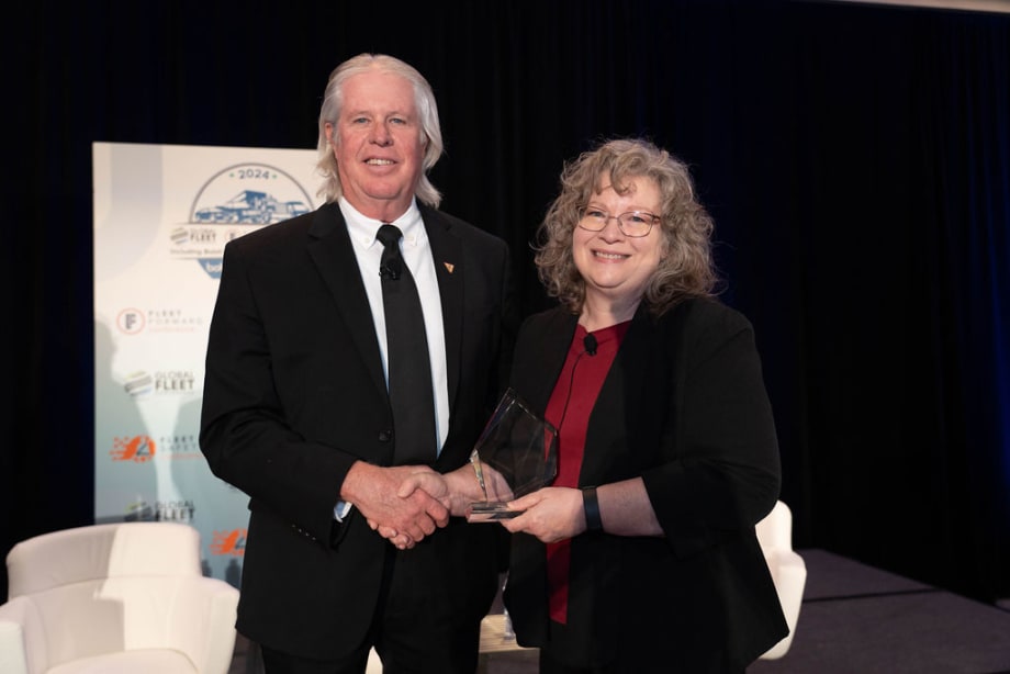 Man in suit receiving award from woman on stage
