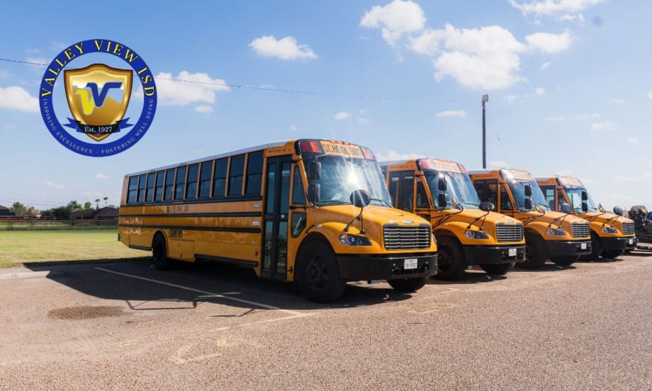 A row of yellow Valley View ISD electric school buses parked outdoors with the district logo in the corner of the image.