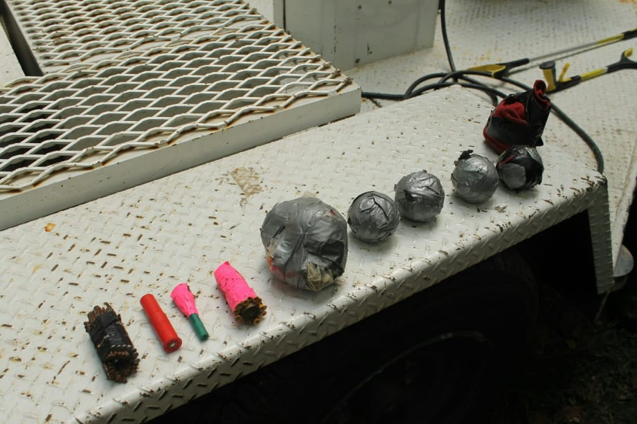 Assorted metal objects, electrical components, and colored tubes on industrial surface