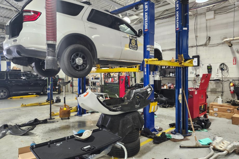 A white Dodge Durango Pursuit is pictured on a blue Rotary lift.