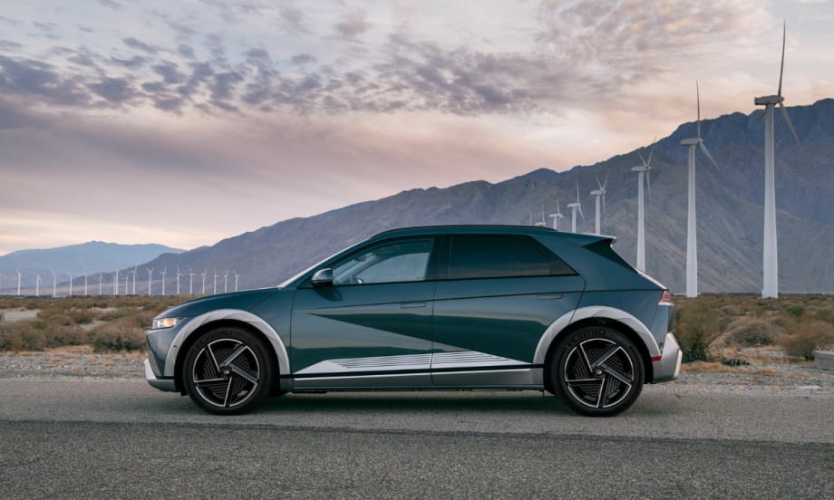 Hyundai IONIQ 5 electric SUV parked near wind turbines, named Best Compact Electric SUV, highlighting fast charging, modern design, and efficiency.