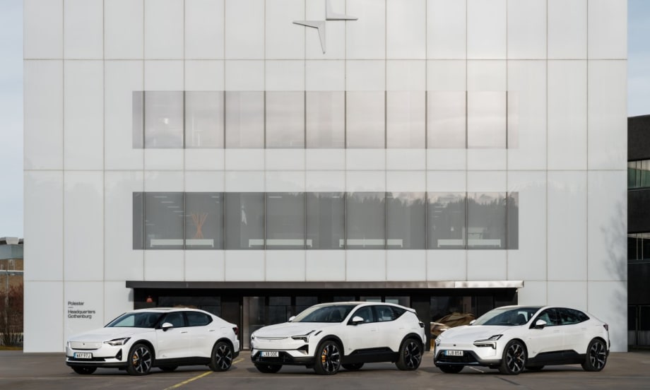 An image of three white Polestar cars lined up in front of a Polestar company building.
