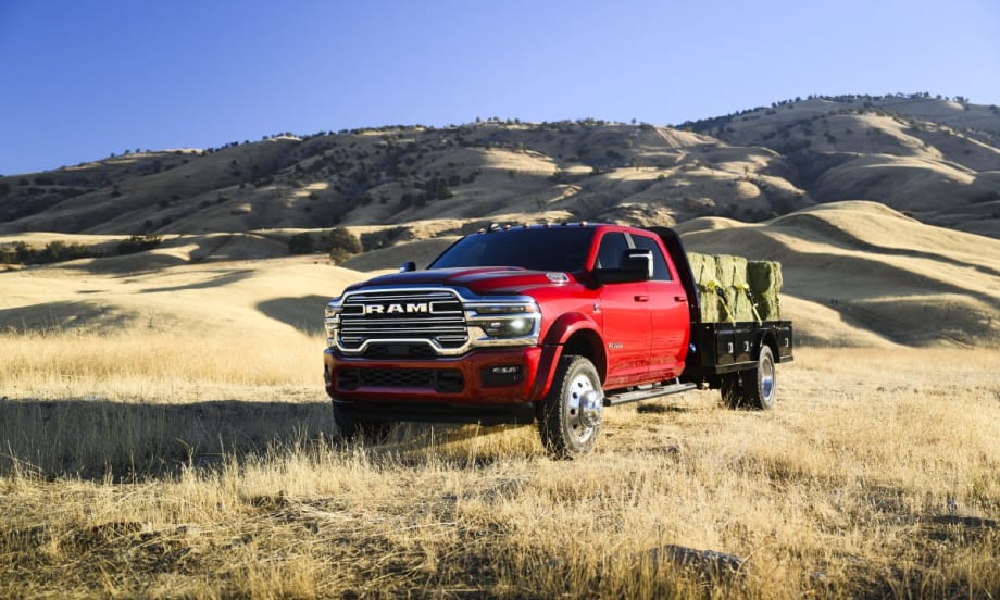 A red 2025 Ram Chassis Cab in a yellow grass field with hills in the background.