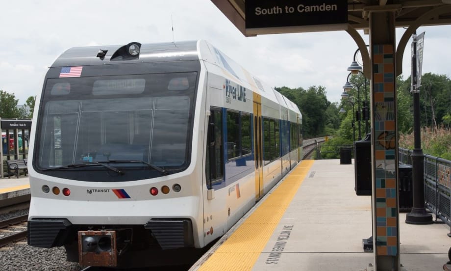 A white NJ TRANSIT River Line rail car at a station.