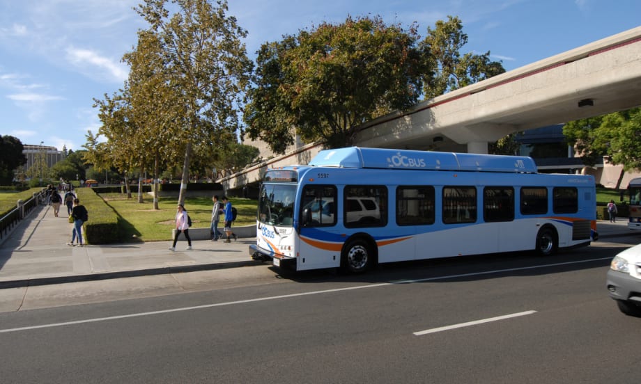 A blue OCTA transit bus at a bus stop.