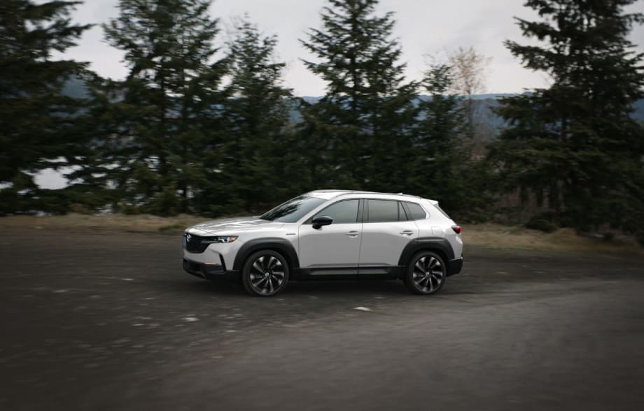 A silver Mazda SUV being driven on a mountain road.
