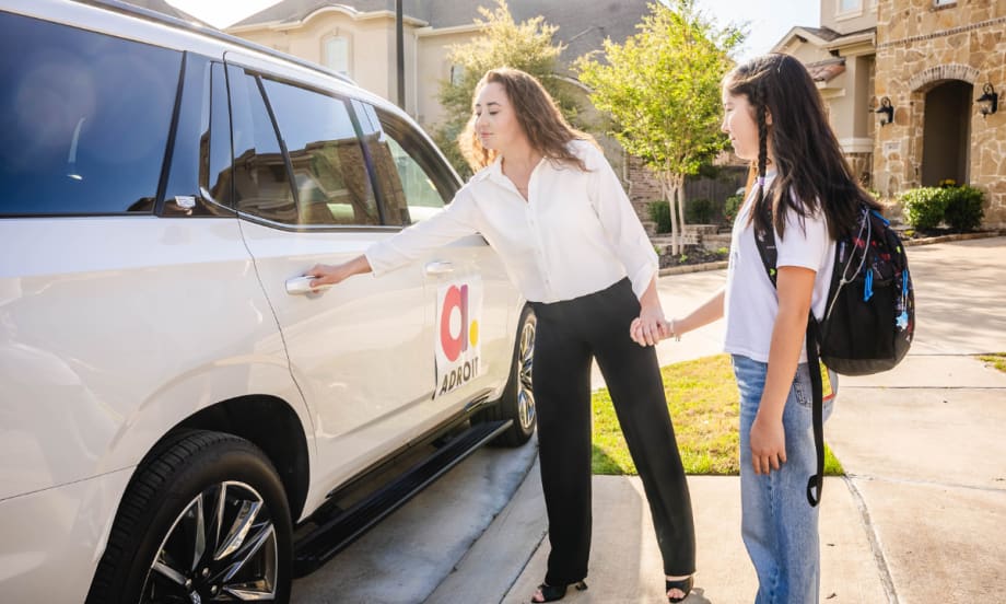 An Adroit driver opening a car door for a student.
