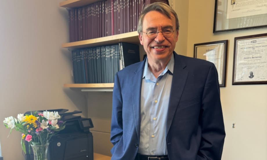 Dimitris Bertsimas poses for a picture in an office.