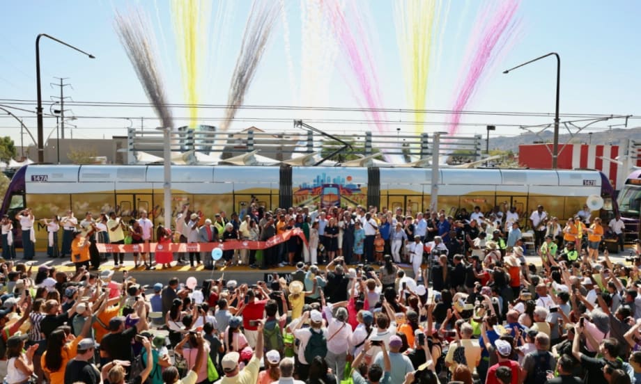 A community ribbon-cutting ceremony with fire works in the background.