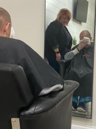 A hairstylist and her client, sitting in a chair