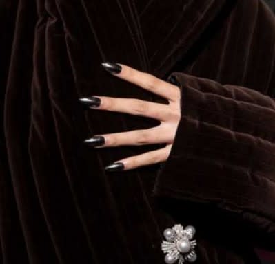 Dark, stiletto nails against a brown fur coat.