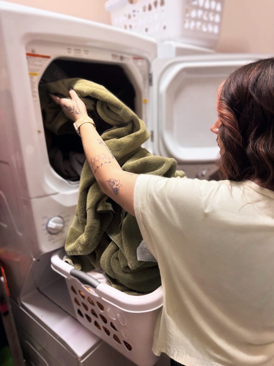 A stylist puts a load in the salon's washing machine.