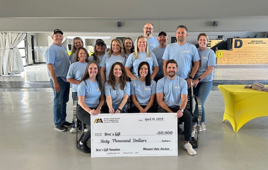 A group of people in matching light blue shirts pose with a check made out to Bree's Gift for $60,000.