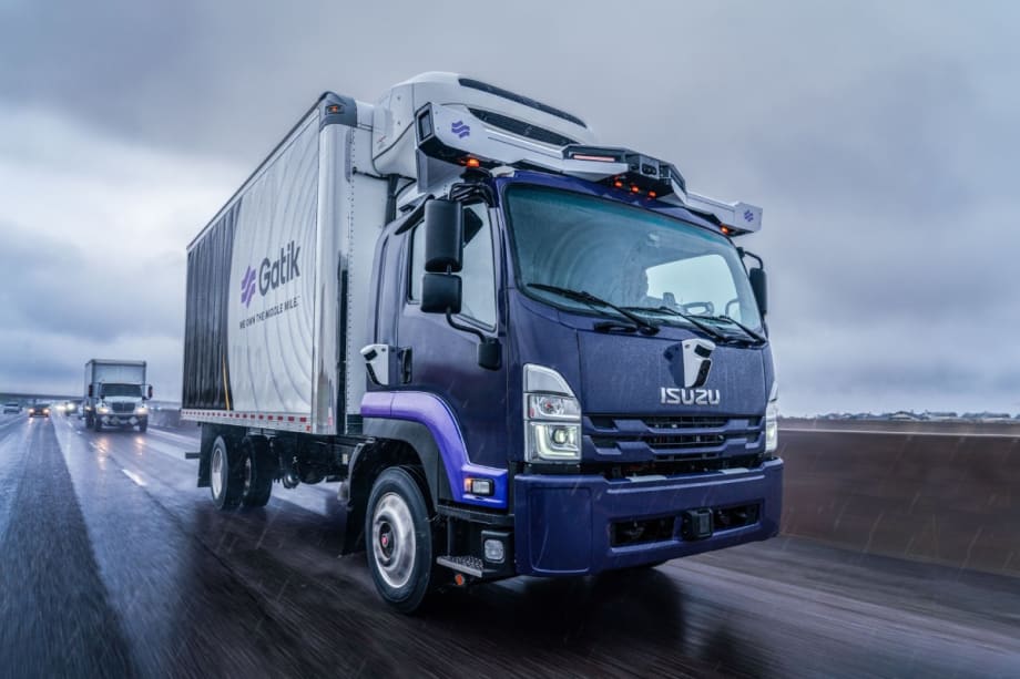 An autonomous Gatik delivery truck drives on the highway in the rain.