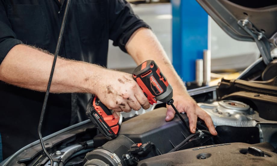 A technician working on a car engine.