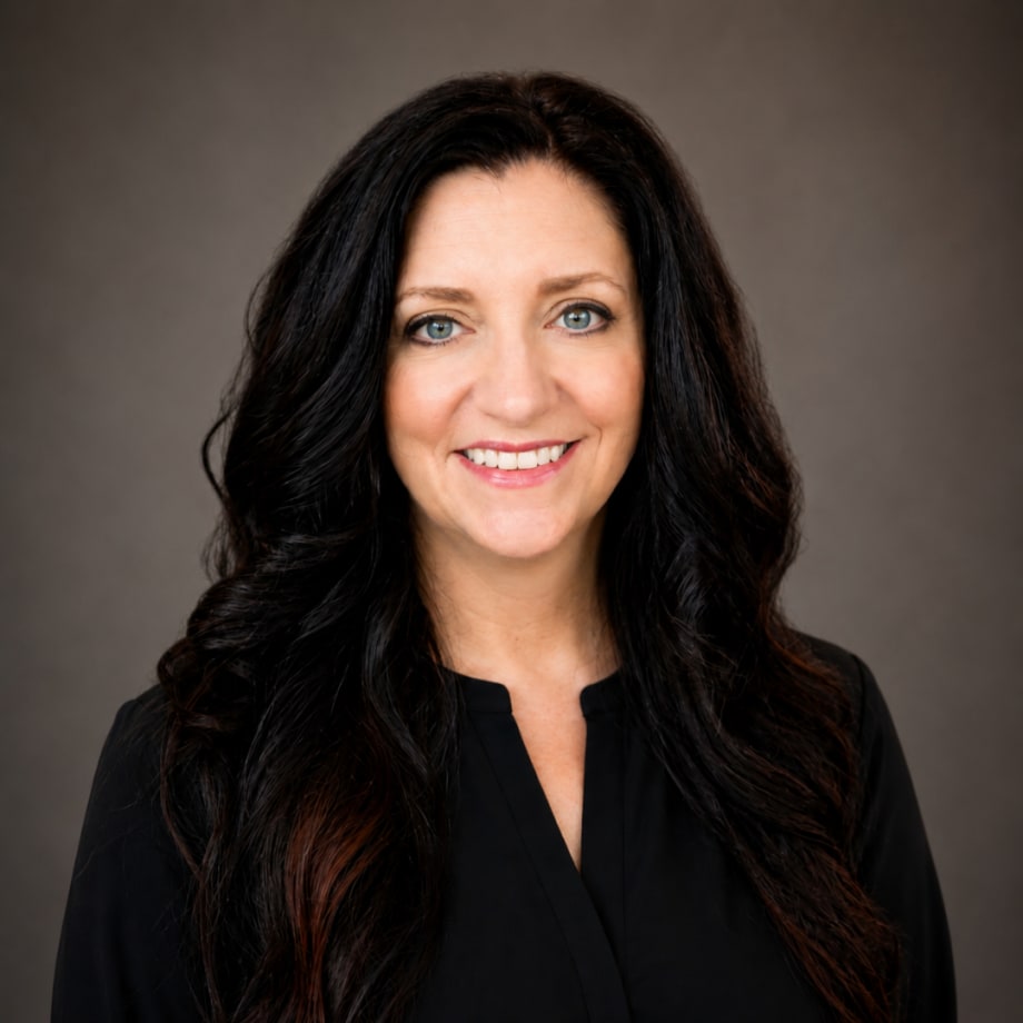 A woman with long dark hair, wearing a black blouse.