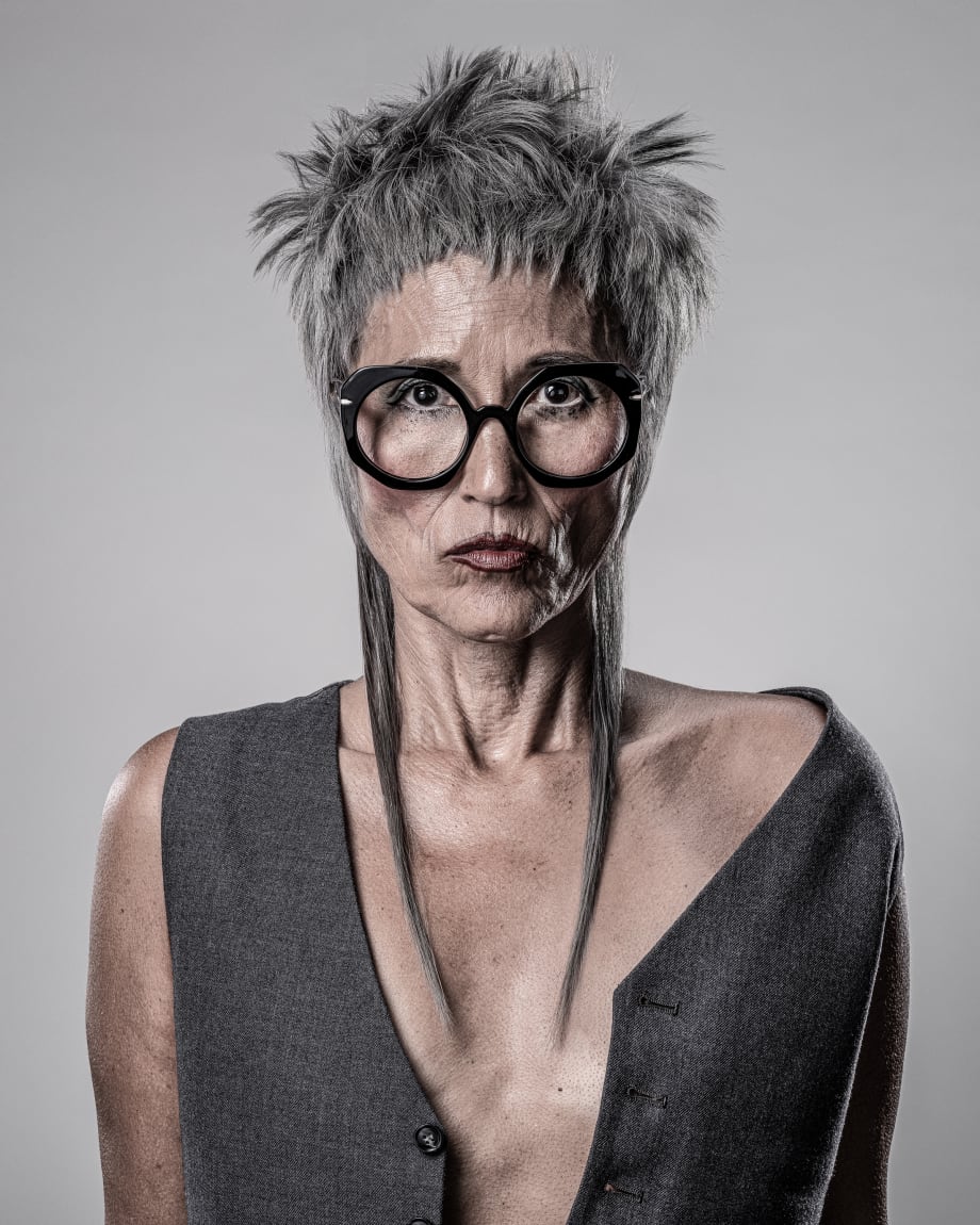 Older woman with big black glasses and a cool hair cut