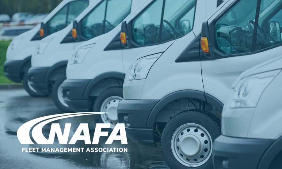 A fleet of white vehicles lined up in a parking lot.
