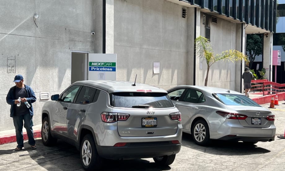 Two rental cars lined up at back entrance of NextCar Priceless rental car outlet near LAX.