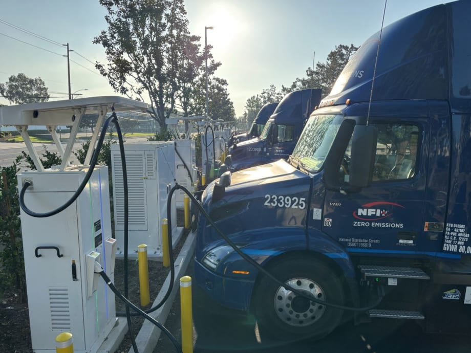 NFI blue electric trucks at charging stations