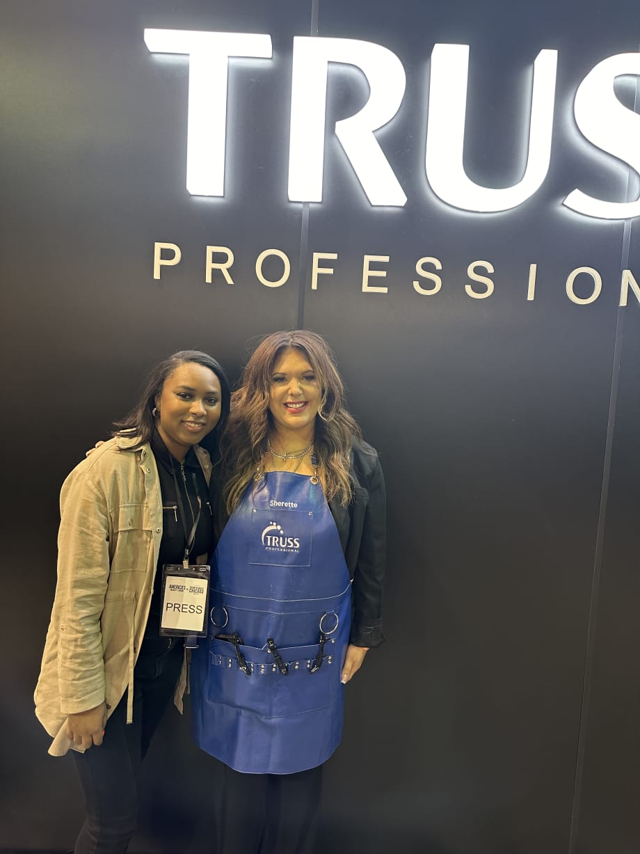 Two women smiling, one is wearing an apron.